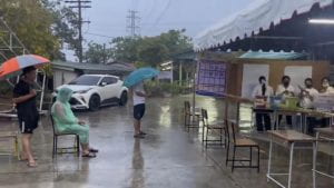 People Standing in the Rain to Monitor Election.